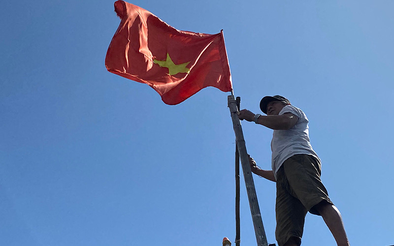 Ngư dân Lê Văn Chiến treo cờ Tổ quốc trên tàu cá. Những hải trình mang vị đời thấm ngọt -0