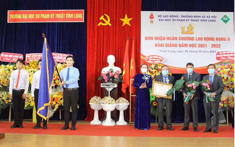 Thừa uỷ quyền, Phó Chủ tịch Uỷ ban nhân dân tỉnh Vĩnh Long Nguyễn Thị Quyên Thanh trao Huân chương Lao động hạng Nhì cho nhà trường vào sáng 23/12. (Ảnh: BÁ DŨNG)