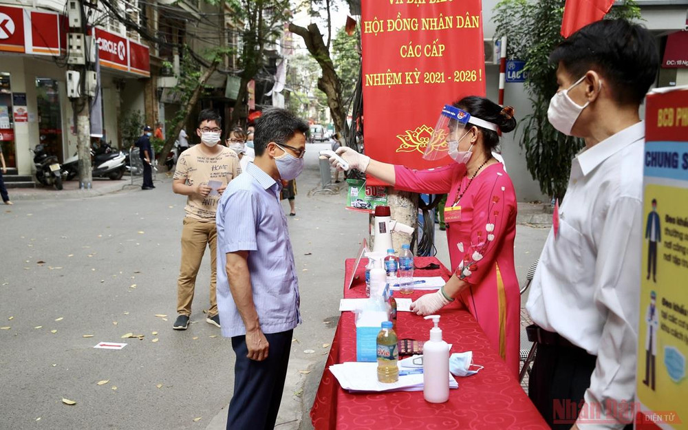 Phó Thủ tướng Vũ Đức Đam kiểm tra thân nhiệt trước khi vào khu vực bỏ phiếu tại phường Trúc Bạch, quận Ba Đình (Hà Nội). Ảnh: Quang Hiếu Người dân Thủ đô trong “Ngày hội non sông” -0