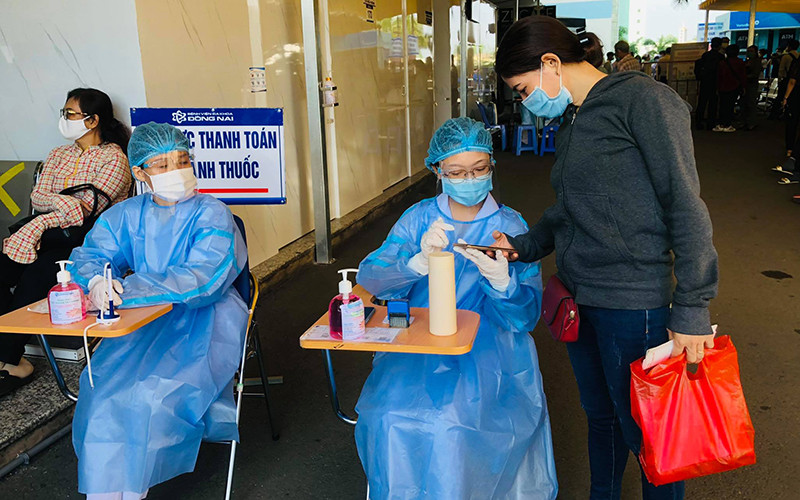 Nhân viên y tế hướng dẫn người dân khai báo y tế để phòng, chống Covid-19. Đồng Nai có thêm sáu ca dương tính với SARS-CoV-2 -0