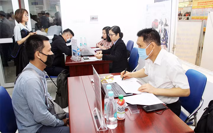 Người lao động trao đổi thông tin tại Sàn giao dịch việc làm Hà Nội. Ảnh: MINH QUYẾT