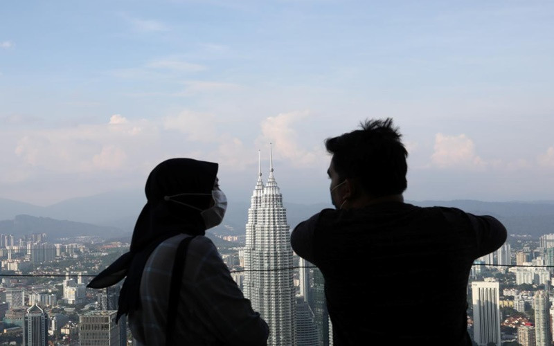 Hai người đeo khẩu trang khi trò chuyện trên Tháp Kuala Lumpur. (Ảnh: Reuters) Châu Á ghi nhận thêm nhiều kỷ lục về dịch bệnh -0