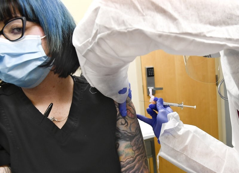 Y tá Kathe Olmstead tiêm vaccine thử nghiệm của Moderna cho cho tình nguyện viên Melissa Harting (bên trái) ở Harpersville, New York, Mỹ. Ảnh: AP. Những liều vaccine Covid-19 đầu tiên sẽ được tiêm cho ai? -0
