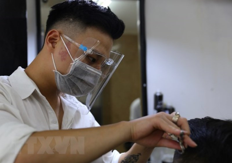 Nhân viên 30 Shine (Lạc Trung, Hai Bà Trưng) đeo khẩu trang và tấm chắn giọt bắn phòng, chống Covid-19 cho khách hàng và bản thân. Hà Nội: Dịch vụ cắt tóc, gội đầu hút khách ngày đầu mở cửa lại -0