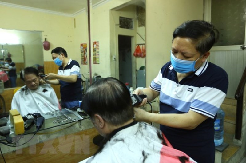 Anh Đào Quang Tiến (chủ tiệm cắt tóc thuộc phường Phạm Đình Hổ) luôn tay phục vụ khách hàng trong sáng mở cửa trở lại. Hà Nội: Dịch vụ cắt tóc, gội đầu hút khách ngày đầu mở cửa lại -0