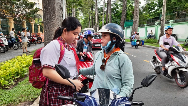 Phụ huynh đưa con đến điểm thi Trường THPT Trưng Vương, quận 1, TP Hồ Chí Minh. Hơn 82 nghìn thí sinh tại TP Hồ Chí Minh bước vào kỳ thi lớp 10 -0