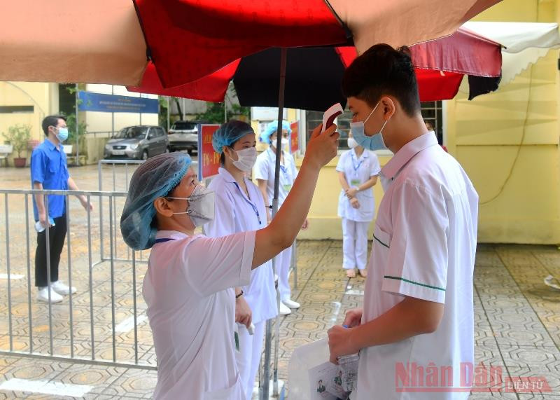 Lực lượng y tế làm nhiệm vụ đo thân nhiệt cho thí sinh trước khi vào phòng thi. Hà Nội bắt đầu kỳ thi tuyển sinh lớp 10 trong điều kiện đặc biệt -0