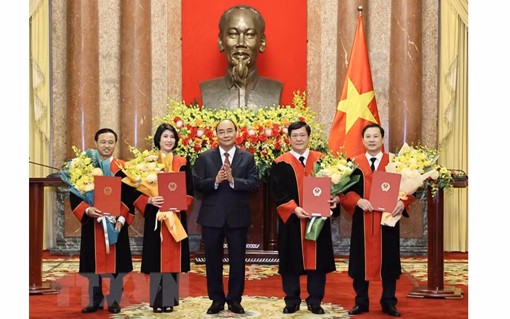 Chủ tịch nước Nguyễn Xuân Phúc trao quyết định và tặng hoa chúc mừng 4 thẩm phán Tòa án Nhân dân tối cao. (Ảnh: TTXVN) 