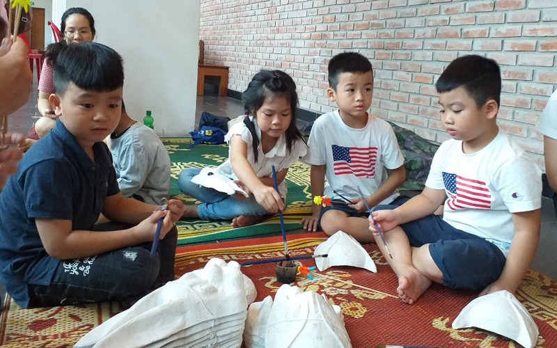 Các em nhỏ trải nghiệm tô mặt nạ giấy bồi (Ảnh: Bảo tàng DTHVN) Bạn đã chọn được nơi trải nghiệm Trung thu năm nay? -0