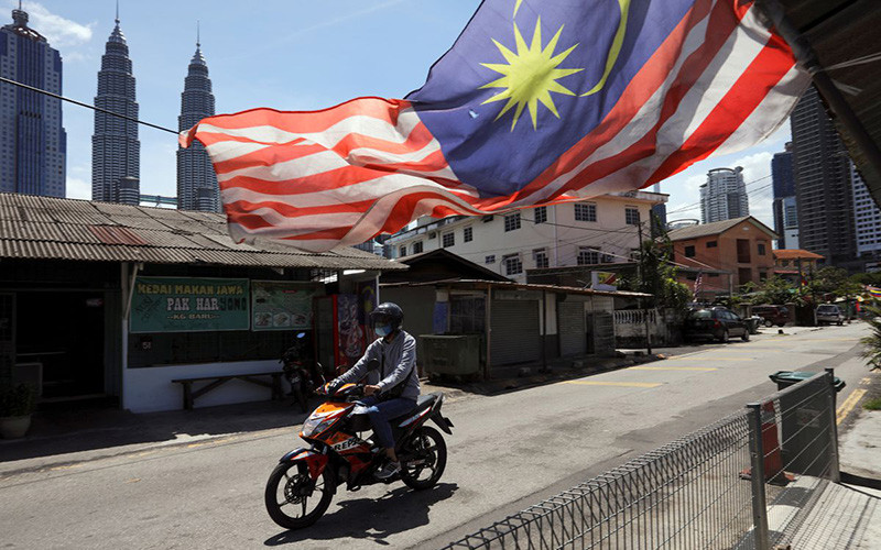 Người đàn ông đeo khẩu trang khi tham gia giao thông tại Kuala Lumpur trong thời gian thành phố này bị phong tỏa để chống Covid-19, ngày 2/2/2021. (Ảnh: Reuters)
