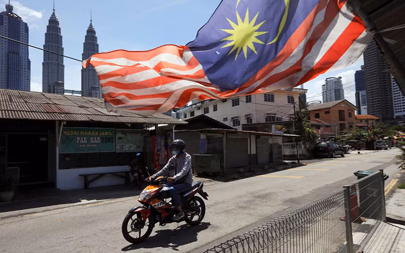 Người đàn ông đeo khẩu trang khi tham gia giao thông tại Kuala Lumpur trong thời gian thành phố này bị phong tỏa để chống Covid-19, ngày 2/2/2021. (Ảnh: Reuters)