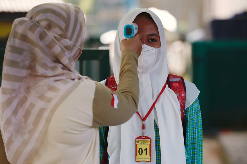 Đo thân nhiệt học sinh tại một trường học ở ngoại ô Jakarta, Indonesia. (Ảnh: Reuters) Ấn Độ có thể đạt đỉnh dịch trong vài ngày tới, Indonesia phát hiện ca nhiễm biến thể B.1.617 đầu tiên -0
