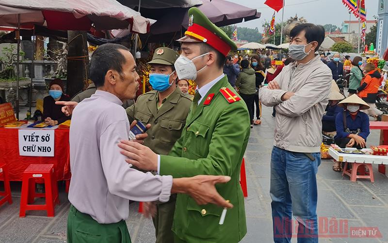 Lực lượng chức năng ngăn không cho một người đàn ông không đeo khẩu trang vào Phủ Tiên Hương. Nam Định đóng cửa chợ Viềng bảo đảm phòng chống dịch -0