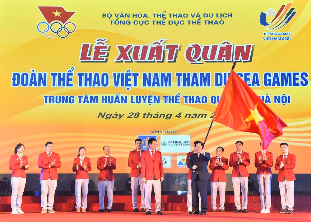 Phó Thủ tướng Thường trực Chính phủ Phạm Bình Minh trao lá cờ Tổ quốc cho Đoàn Thể thao Việt Nam tham dự SEA Games 31. 