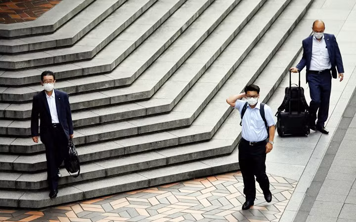 Người dân chấp hành quy định đeo khẩu trang tại Tô-ki-ô, Nhật Bản. Ảnh ROI-TƠ