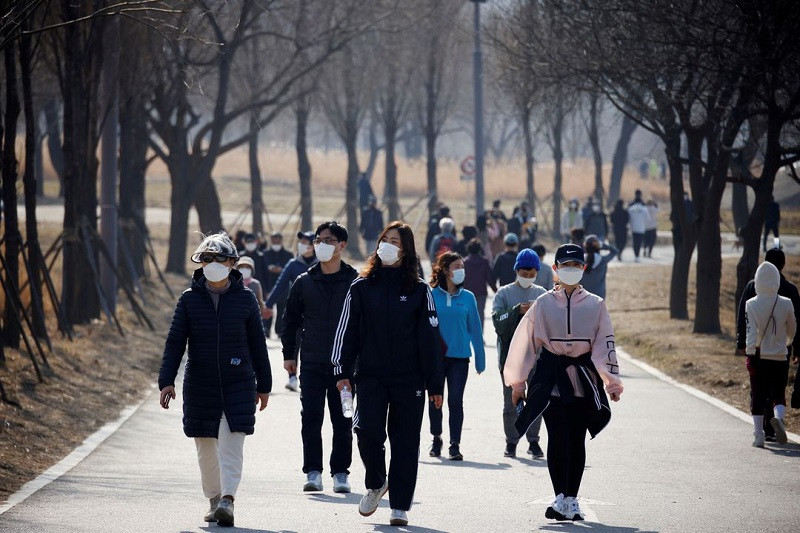 Người dân đeo khẩu trang đi dạo tại công viên Hanriver ở Seoul, Hàn Quốc, ngày 21/2/2021. (Ảnh: Reuters) Malaysia dỡ bỏ hạn chế đi lại đối với công dân đã tiêm ngừa Covid-19 đầy đủ -0