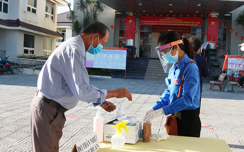 Sát khuẩn trước khi vào khu vực bỏ phiếu. Xung kích tình nguyện hỗ trợ bầu cử -0