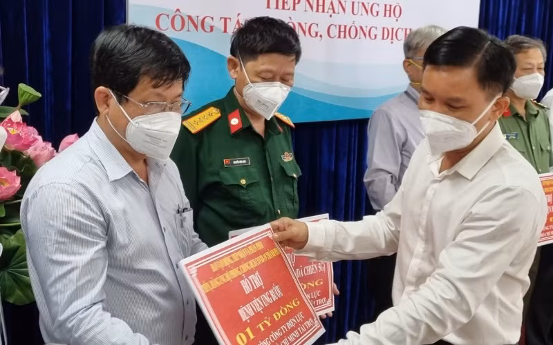 Đại diện EVNHCMC trao bảng biểu trưng kinh phí ủng hộ phòng, chống dịch Covid-19 cho các đơn vị.