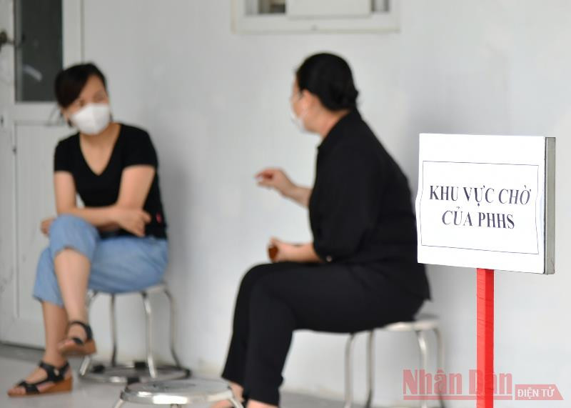Phụ huynh trao đổi với nhau tại điểm chờ Trường THCS Ái Mộ (quận Long Biên). Hà Nội bắt đầu kỳ thi tuyển sinh lớp 10 trong điều kiện đặc biệt -0