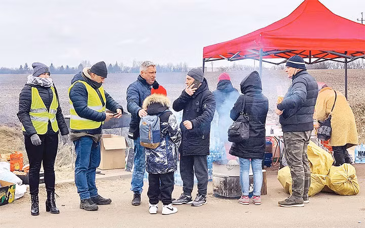 Một em bé sơ tán lạc mẹ đang được các tình nguyện viên Nga giúp.