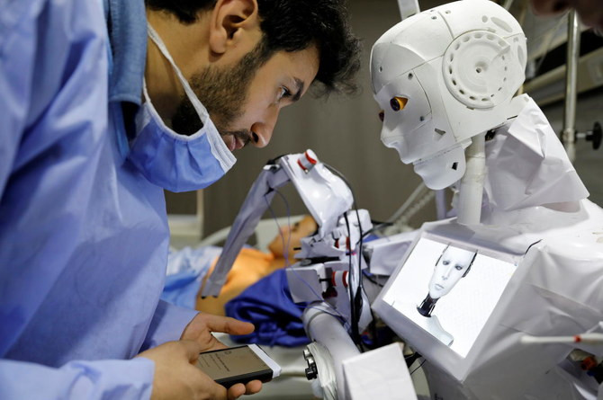 Kỹ sư cơ điện tử người Ai Cập 26 tuổi Mahmoud El Komy đứng bên cạnh robot Cira 3 do mình phát minh. Ảnh: Reuters. Ai Cập phát minh robot xét nghiệm Covid-19 -0