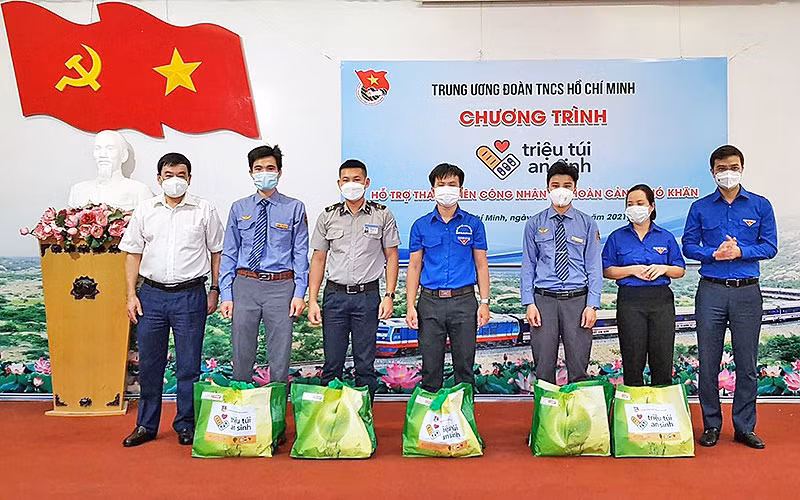 Đồng chí Bùi Quang Huy (ngoài cùng bên phải) trao “Túi an sinh” tặng đại diện thanh niên công nhân có hoàn cảnh khó khăn.