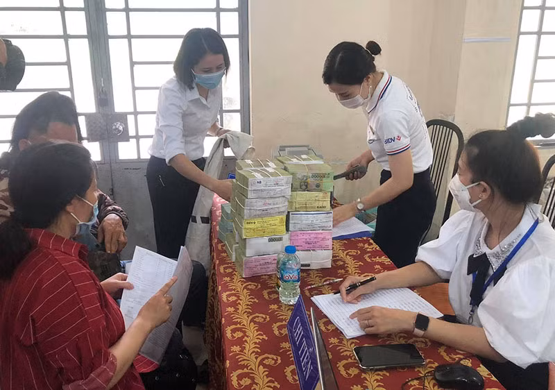 Người dân đến nhận tiền đền bù vào sáng 8-9.