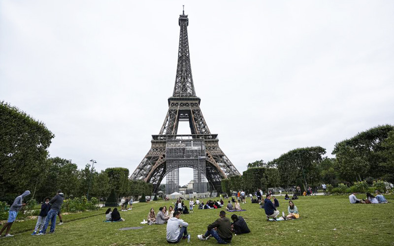Người dân và du khách thư giãn tại khu vườn Champ-de-Mars bên cạnh Tháp Eiffel ở Paris hôm 16/7 (Ảnh: AP) Sau gần 9 tháng, du khách đã được ngắm toàn cảnh Paris từ Tháp Eiffel -0