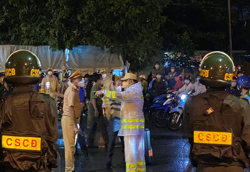 Lực lượng Công an tỉnh Đồng Nai đội mưa trong đêm 1/10 hỗ trợ người dân về quê. Đồng Nai hỗ trợ đưa hơn 6.000 người dân về quê -0