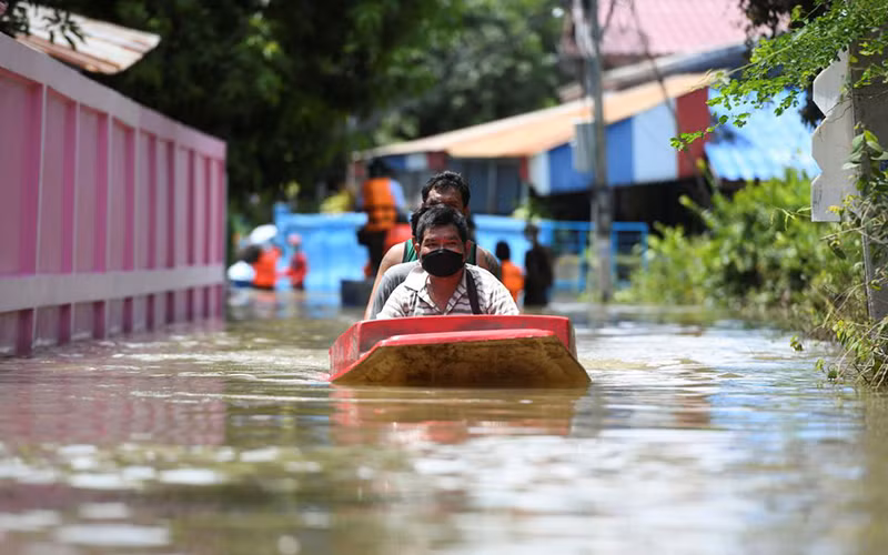 Người dân đi thuyền qua một con đường bị ngập nặng ở tỉnh Lopburi, Thái Lan. (Ảnh: Reuters)