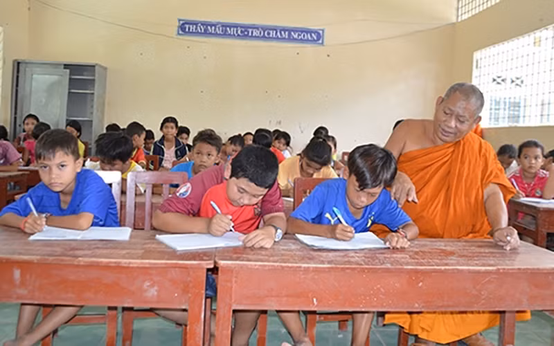 Thượng tọa Tăng Sa Vông, trụ trì chùa Cái Giá ở xã Hưng Hội, huyện Vĩnh Lợi dạy chữ cho học sinh dân tộc Khmer.