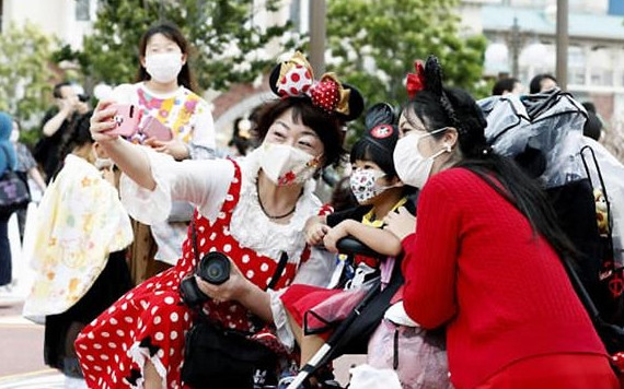 Du khách tới Công viên giải trí Disneyland Tokyo phải đeo khẩu trang bắt buộc (Ảnh: CNN)