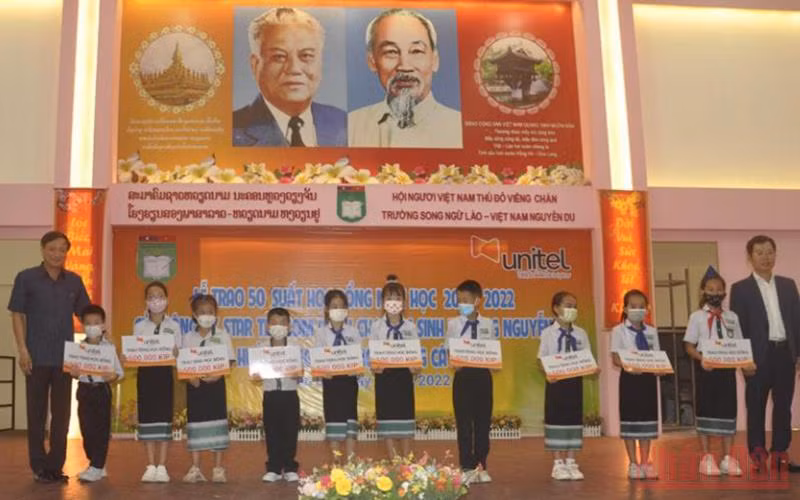 Đại sứ Việt Nam Nguyễn Bá Hùng cùng các học sinh Trường song ngữ Lào-Việt Nam Nguyễn Du tại buổi lễ. (Ảnh: Cộng tác viên)