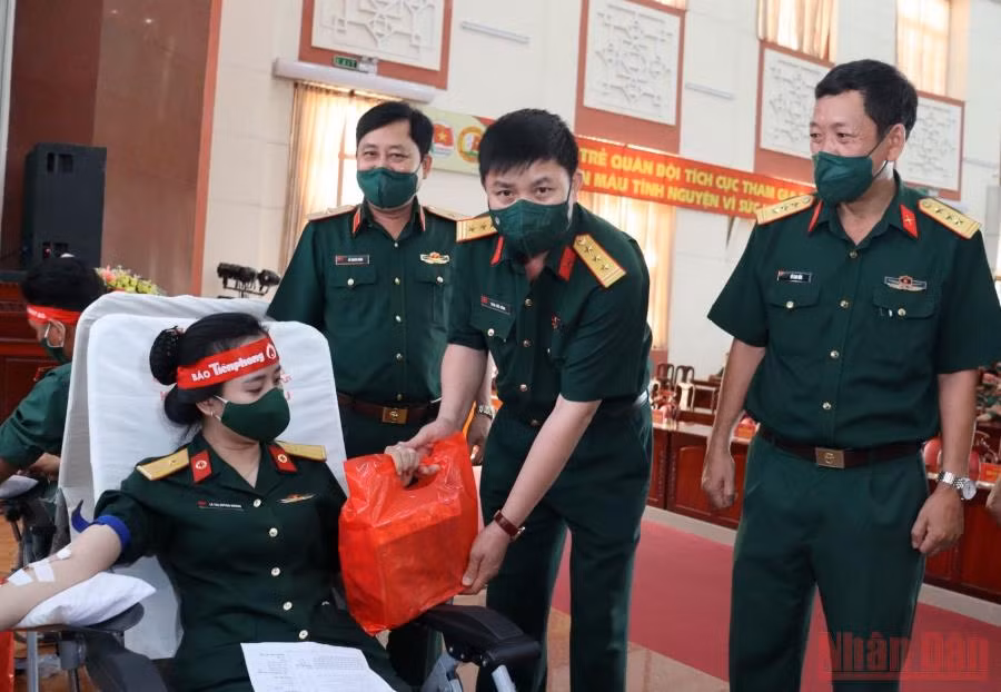 Thượng tá Trần Viết Năng tặng quà nữ quân nhân Trường Sĩ quan Lục quân 2 tham gia hiến máu tình nguyện.