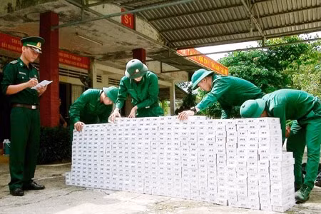 Cán bộ, chiến sĩ Ðồn Biên phòng Cửa khẩu quốc tế Bình Hiệp (tỉnh Long An) kiểm đếm tang vật vụ buôn lậu thuốc lá. Ảnh: MINH LUẬN 