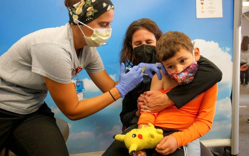 Cậu bé 5 tuổi Renan Rojas ngồi trong lòng mẹ khi tiêm vaccine Pfizer-BioNTech tại Bệnh viện nhi Rady ở San Diego, California, Mỹ, ngày 3/11/2021. (Ảnh: Reuters) Costa Rica yêu cầu tiêm vaccine ngừa Covid-19 cho trẻ em -0