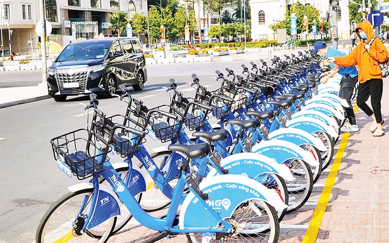 Các bạn trẻ trải nghiệm xe đạp công cộng tại trung tâm TP Hồ Chí Minh. 