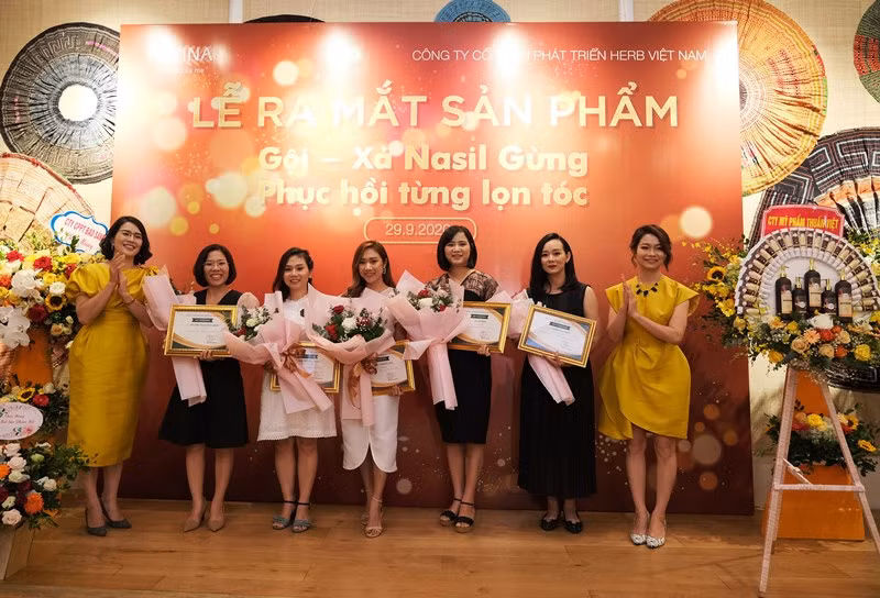 Tổng Giám đốc HEVINA Đỗ Thị Nhàn trao giấy chứng nhận và tặng hoa cho các nhà phân phối mỹ phẩm thảo dược của HEVINA năm 2020.