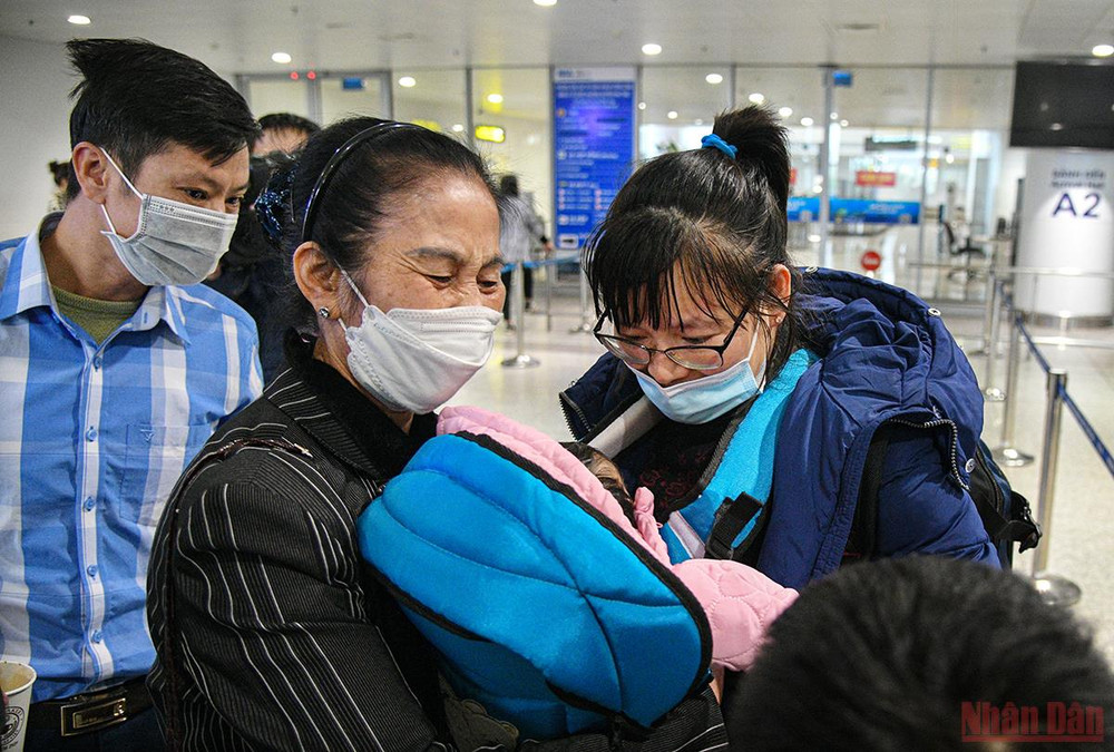 Bà Lê Thị Đan, ở Đa Tốn, Gia Lâm, Hà Nội ôm chặt cháu nội khi đón tại sân bay. (Ảnh: THÀNH ĐẠT) Đồng bào trở về từ Ukraine: Chuyến hồi hương hạnh phúc nhất -0