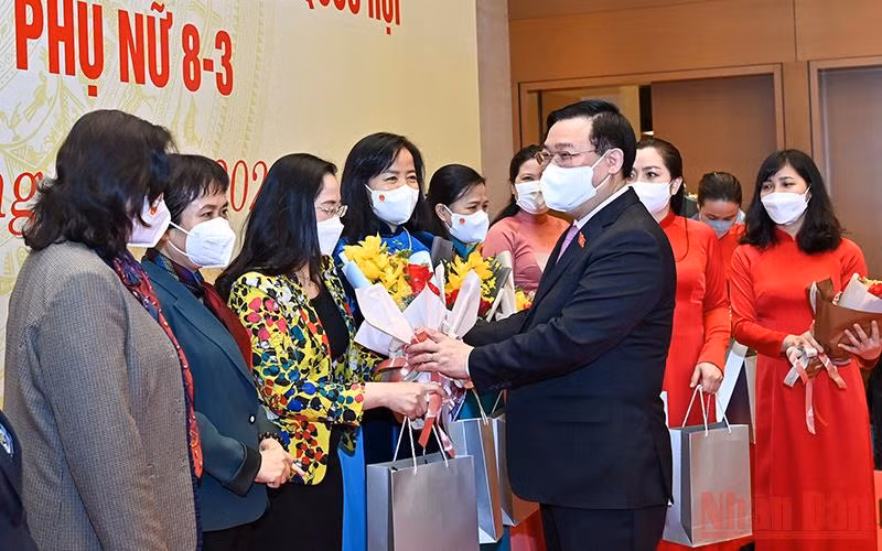 Chủ tịch Quốc hội Vương Đình Huệ tặng hoa, tặng quà chúc mừng các nữ đại biểu. (Ảnh: DUY LINH)