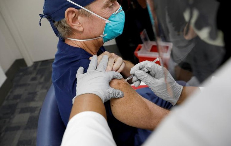 Nhân viên y tế được tiêm vaccine Covid-19 của Pfizer - BioNTech tại Bệnh viện Jackson Memorial ở Miami, Florida, Mỹ, ngày 15-12-2020. Ảnh Reuters. CDC: Sốc phản vệ do vaccine Covid-19 gấp 10 lần cúm, nhưng tiêm phòng vẫn cần thiết -0