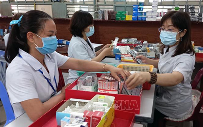 Nhân viên y tế chuẩn bị thuốc để cấp cho bệnh nhân điều trị ngoại trú có tham gia bảo hiểm y tế. (Ảnh minh họa: TTXVN)