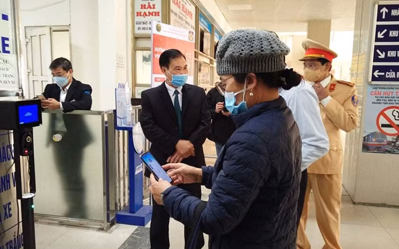 Lực lượng Cảnh sát giao thông Hà Nội hướng dẫn người dân thao tác quét mã QR để khai báo y tế ở bến xe.