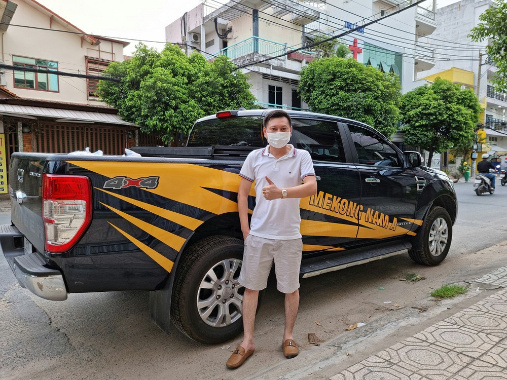 Giám đốc công ty Mekong Nam Á Nguyễn Thanh Thản bên một trong những chiếc ô-tô chở hàng cứu trợ và phát cơm từ thiện. Nghĩa cử đẹp phía sau hàng nghìn suất cơm cho người cơ nhỡ -0