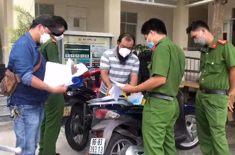 Trần Xuân Đạt (áo sọc ngang), đối tượng chính trong đường dây làm Giấy xét nghiệm Covid-19 giả. 