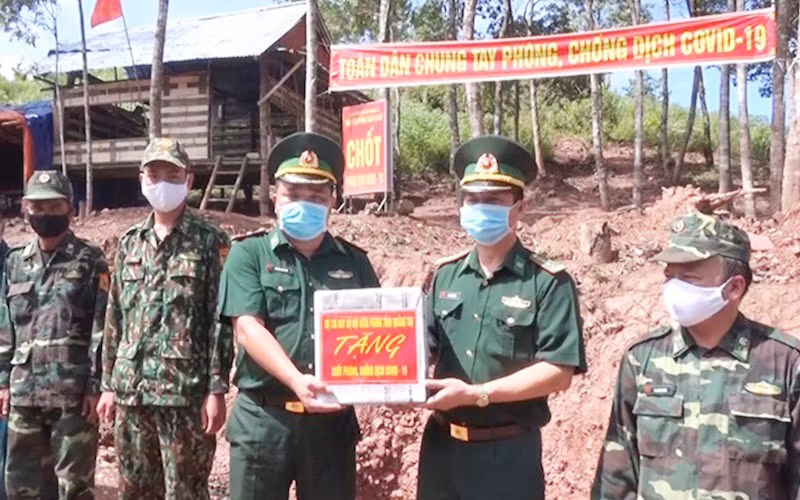 Đại tá Lê Văn Phương (bên phải) tặng quà cho chiến sĩ làm nhiệm vụ tại chốt phòng, chống Covid-19 thuộc Đồn Biên phòng cửa khẩu quốc tế La Lay.