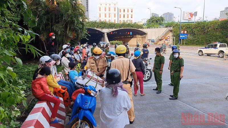 Các cơ quan chức năng tuyên truyền, vận động người dân quay về nơi ở khi đang trên đường về quê bằng xe máy tại khu vực hầm Thủ Thiêm, TP Thủ Đức. (Ảnh: QUANG QUÝ)