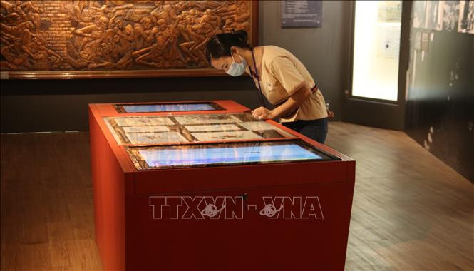 Khách tham quan trải nghiệm công nghệ tra cứu thông tin tại Bảo tàng phụ nữ Nam Bộ. Ảnh: TTXVN.