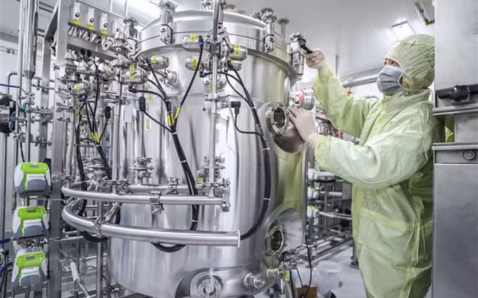 Nhân viên Tập đoàn dược quốc gia Trung Quốc (Sinopharm) điều chỉnh thiết bị sản xuất vắcxin tại nhà máy của Tập đoàn ở Bắc Kinh (Ảnh: THX/TTXVN)