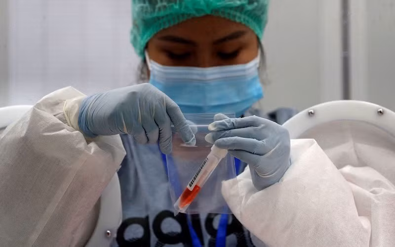 Nhân viên y tế lấy mẫu xét nghiệm Covid-19 từ du khách nước ngoài tại Phuket. (Ảnh: REUTERS)